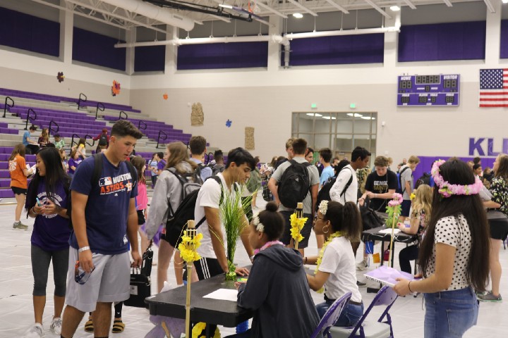 Students collecting their yearbook from the staff at the cafeteria