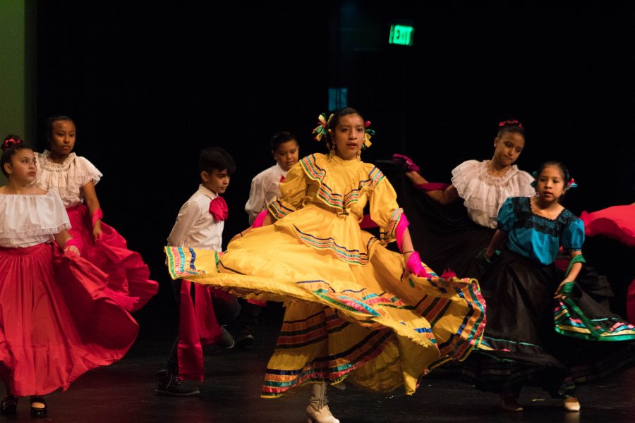 Girls in their Mexican-themed costumes dancing in the auditorium on Saturday in front of a crowd at the multicultural event.
