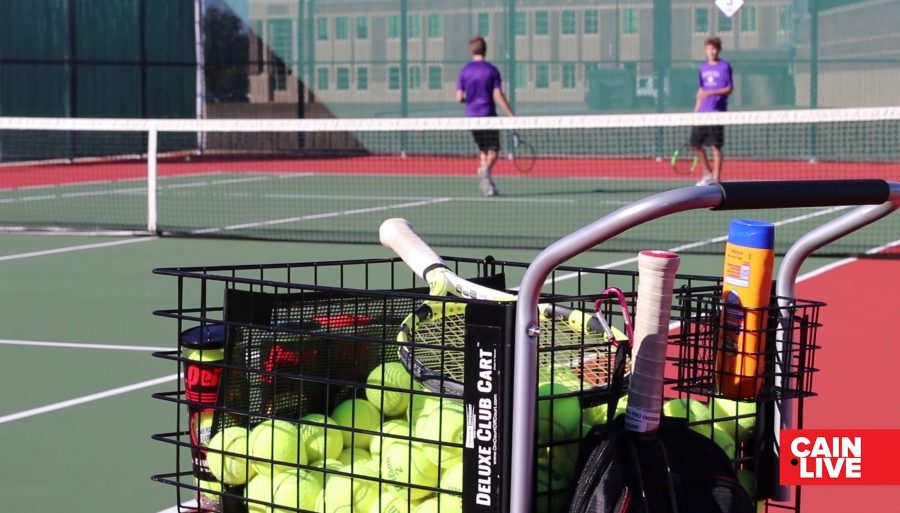 The Tennis Team practicing boy's doubles on the Klein Cain courts.