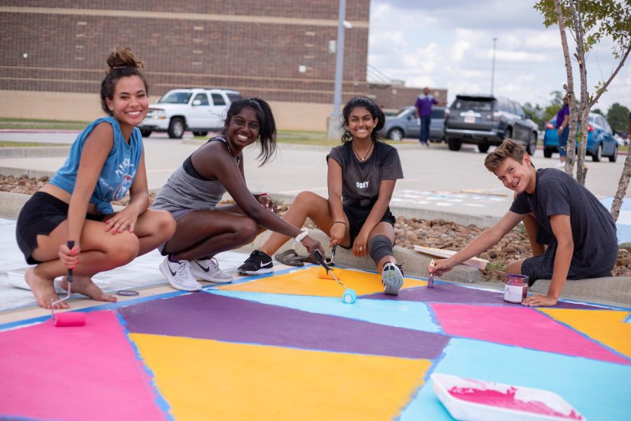 Students work together to paint a senior parking spot.