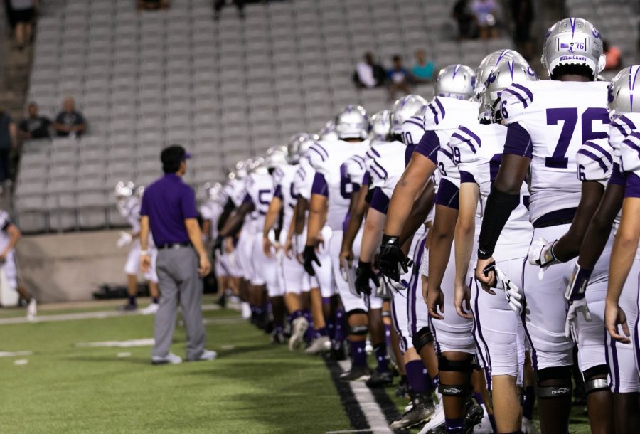 The football players lining up at the end of the game. They're about to start shaking the other's team's hand. Photo by: Zoe Rivers