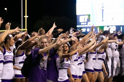 The cheer squad and football team waving at the crowd at the end of the game. Photo by: Zoe Rivers