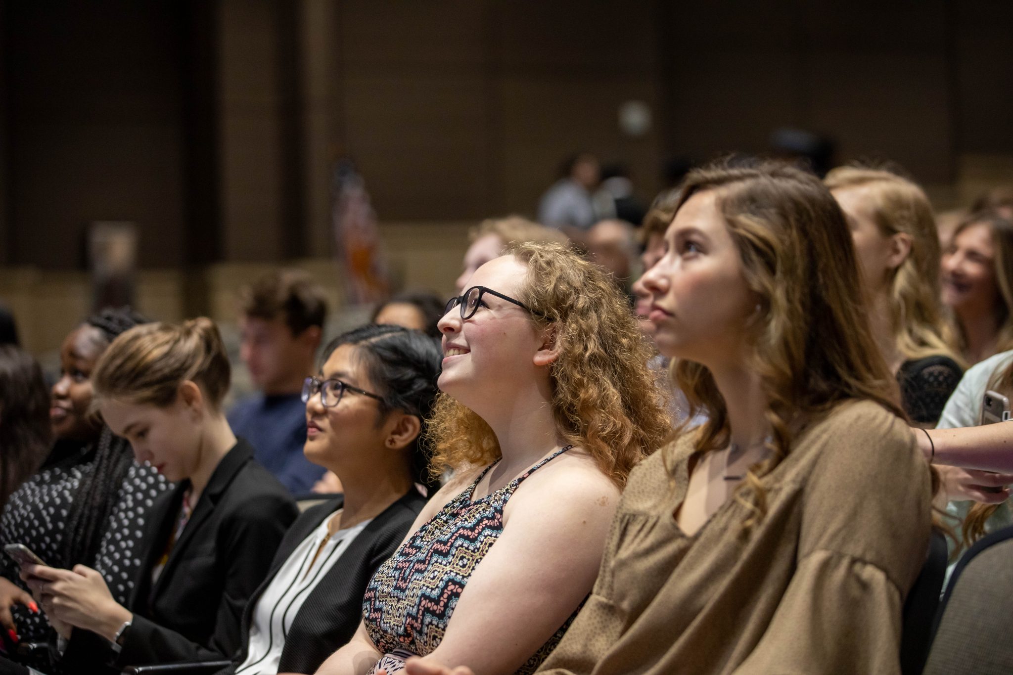 Terrin Bourgeois and Mikaela Awe sitting together during the ceremony in the auditorium. Photo by Zoe Rivers