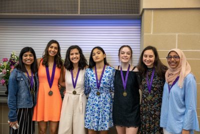 Reenu Renny, Anya Robinson, Mariana Martinez, Maxine Agulto, Hannah Hughes, Emilia Calina, and Eisha Ahmed posing together after the ceremony. They've been friends throughout their high school careers and helped each other get to where they are now. Photo by Zoe Rivers